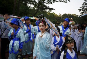 A Buddhist believer wearing a traditional costume waits for a lotus lantern parade in celebration of the upcoming birthday of Buddha in Seoul, South Korea, on May 16, 2015.