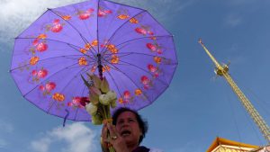 A Cambodian woman prays in front of a shrine out side the Royal Palace in Phnom Penh. People usually dress in white and distribute kheer as according to Buddhist lore, on this day a woman named Sujata had offered Buddha a bowl of milk porridge