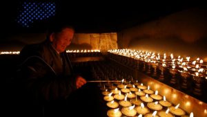 A devotee lights butter lamps on the birth anniversary of Buddha