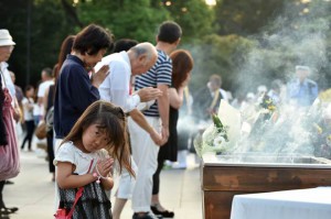 People pray for the victims of the 1945 atomic bombing, at the Peace Memorial Park in Hiroshima on August 6, 2015.