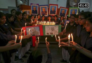 Schoolgirls hold candles as they sit in front of a portrait of former President APJ Abdul Kalam during a prayer ceremony in Chennai on July 28, 2015.