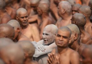 Newly initiated Naga Sadhus (Hindu holy men) sit as they perform rituals on the banks of the Ganges river during the Kumbh Mela, in Allahabad.