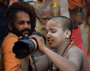 Sadhus shoot on a DSLR camera on a bank of Ganga river during the ongoing Kumbh Mela festival, in Allahabad.