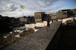 A boy flies his kite in a cemetery in the Vila Operaria Favela of Rio de Janeiro, Brazil.