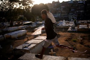 A boy runs as he holds his kite in a cemetery in the Vila Operaria Favela of Rio de Janeiro, Brazil.