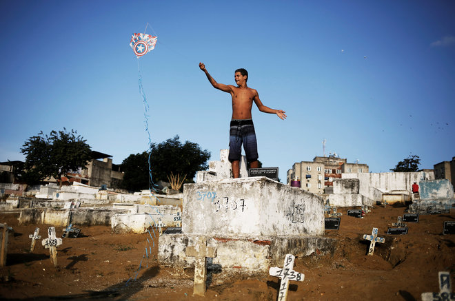 A man flies his kite in a cemetery in the Vila Operaria Favela of Rio de Janeiro, Brazil. Some $12.3 billion has been spent to host South America's first Olympic Games, which kick off on August 5 but for those who live in the slums, there are few public spaces for sports or recreation.