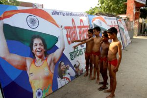 Budding wrestlers in Mokhra, the native village of Olympic medal winner Sakshi Malik, look at her poster in Rohtak on August 23