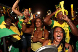 Fans cheer while watching a broadcast of Jamaica's Usain Bolt winning the men's 100 meters final in Kingston, Jamaica.