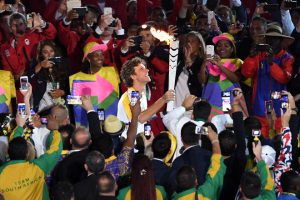 Former Brazilian tennis player Gustavo Kuerten carries the Olympic torch during the opening ceremony of the Rio 2016 Olympic Games at Maracana Stadium in Rio de Janeiro on August 5, 2016.