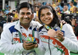 Sakshi Malik and her coach Kuldeep Singh celebrate after winning bronze against Kyrgyzstan's Aisuluu Tynybekova in the women's wrestling freestyle 58kg competition