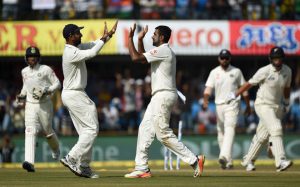 India’s bowler Ravichandran Ashwin (C) celebrates with teammate Cheteshwar Pujara after taking the wicket of New Zealand batsman Ross Taylor during the fourth day of third Test cricket match between India and New Zealand at the Holkar Cricket Stadium in Indore on October 11, 2016.