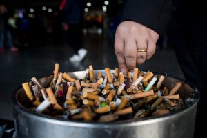 A man grinding out his cigarette in an ashtray at a railway station in Shanghai. Smoking-related diseases claim 7 millions of lives each year in the world, the World Health Organization reported on May 30, 2017, calling to increase taxes on tobacco.