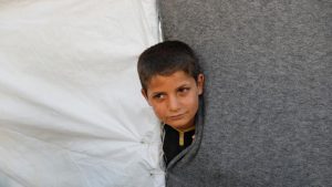 An evacuee looks out from a tent inside a refugee camp for people who fled from Mosul due to fighting between Iraqi forces and Islamic State militants, on the outskirts of Erbil, Iraq June 10, 2017.