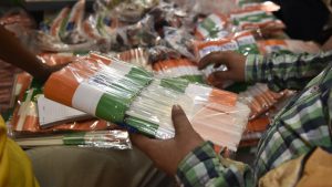 A person buys Indian national flags in bulk at a market for the upcoming Independence day celebrations, in New Delhi. Tricolour related paraphernalia ranging from flags to face paint, clothing and banners sees exceptionally high demand among buyers in the days leading up to the eve of August 15.