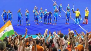 Indian men's hockey players celebrate with supporters on winning the bronze medal after defeating Pakistan 2-1