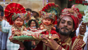 A devotee carries idols of Hindu Lord Jagannath, his sister Subhadra and brother Balabhadra