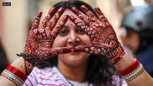 Jammu woman shows her hands decorated with henna