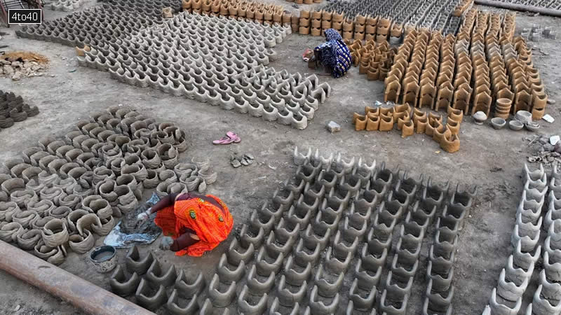 Women make clay stoves to be sold to the devotees who will be staying on the banks of the Ganges river.